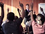 audiencia-com-os-bracos-levantados-na-sala-de-palestras-durante-o-seminario